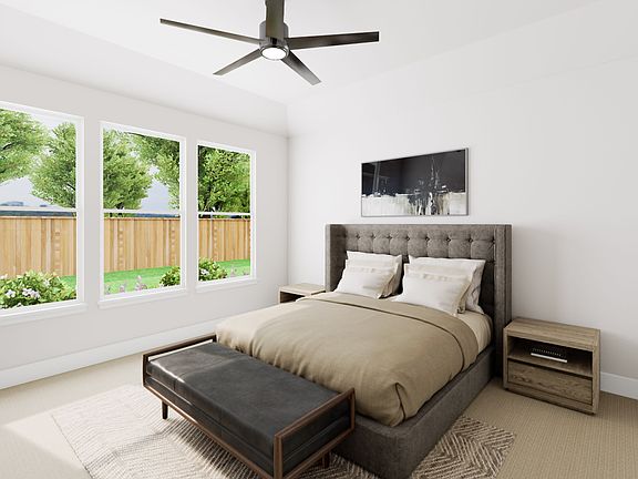 A modern and cozy bedroom with a large window overlooking a lush, green backyard, featuring a sleek