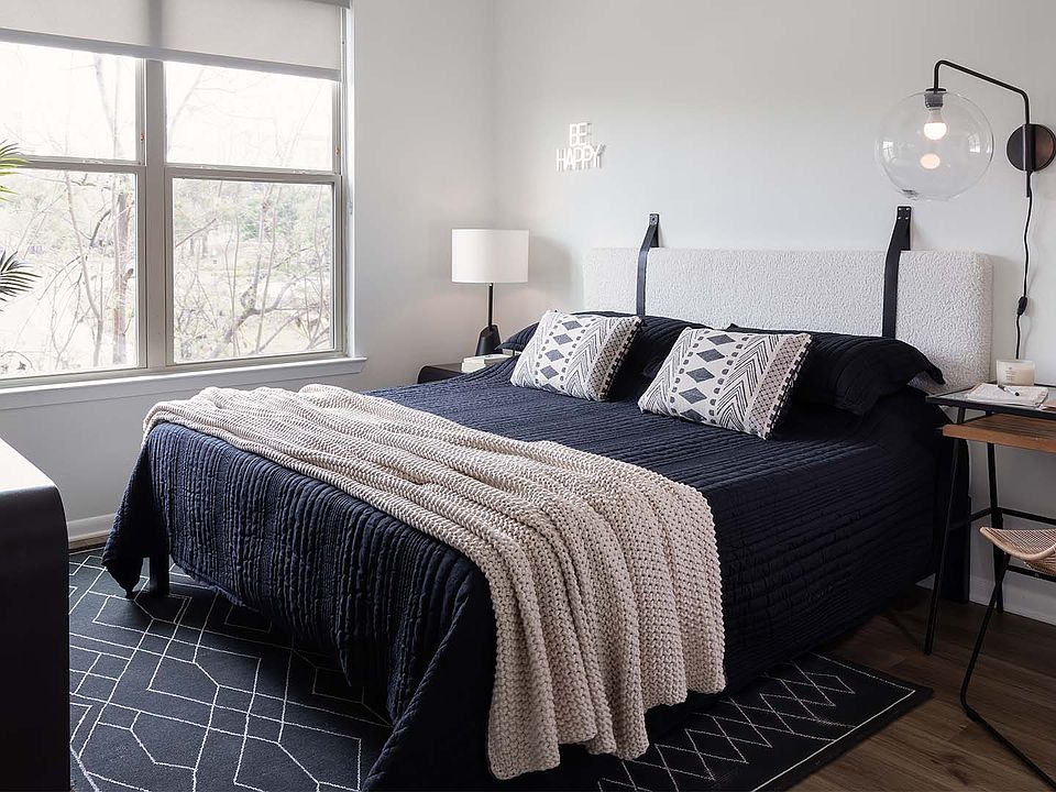 Spacious apartment bedroom with wood-style flooring.