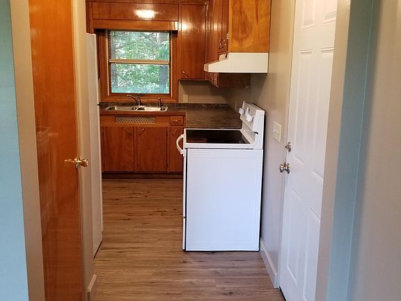 Looking into the kitchen from the living room. There is a coat closet opposite the new (exterior-grade) entry door.