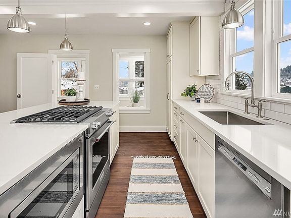 Kitchen appliances include stainless Bosch dishwasher, Samsung undercabinet microwave, KitchenAid Professional Series range with gas (propane) cooktop and stainless undermount sink.