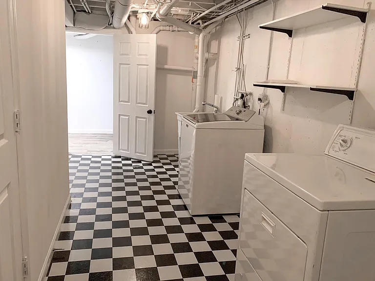 Oversized laundry room with storage area beneath the staircase.