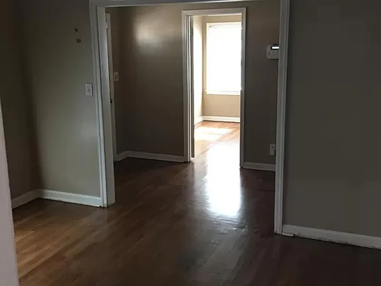 From kitchen looking through living room to front entryway and bedroom #1/office
