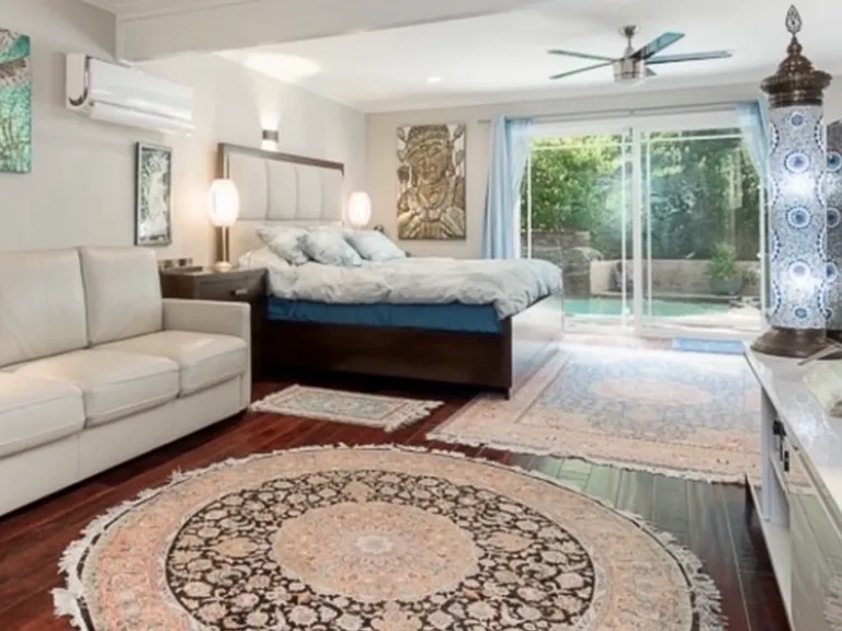 Private downstairs master bedroom is massive with real hardwood floors, wine cellar, sink, quartz bar, lots of windows, and oversized glass doors leading to the relaxing waterfall jacuzzi tub and yard.