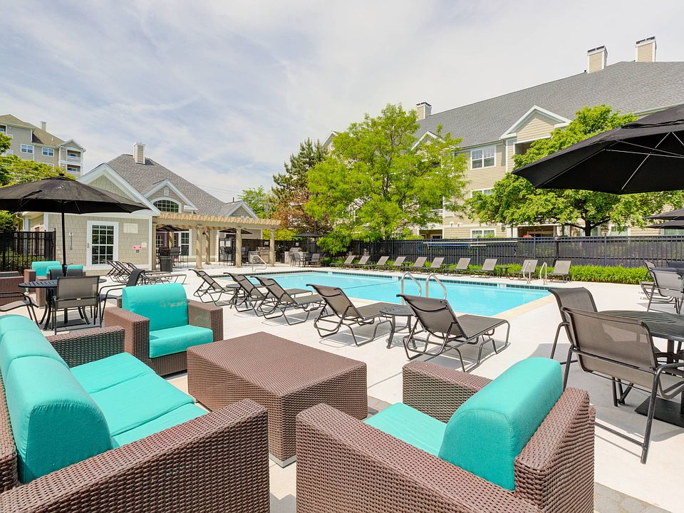 View of pool with soft seating, loungers, tables and umbrellas