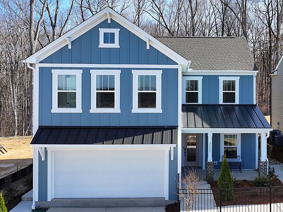 A blue and white house with a garage and a porch.