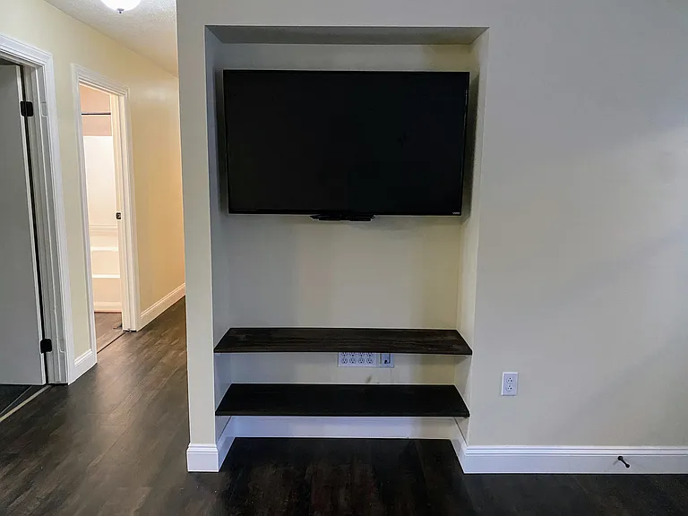 Built in Entertainment Center:

Currently includes a 50" TV mounted onto a Mantle Mount. The mount pulls your tv out and down with a swivel function. There are also wire pass through ports in the wall. 

You can mount your own TV as well.