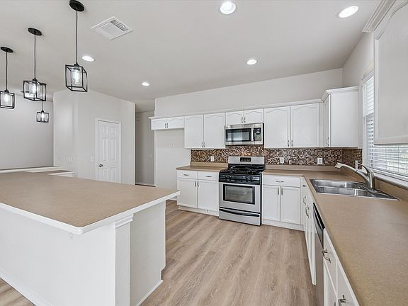 Kitchen with stainless appliances, huge island, desk space, and pantry.