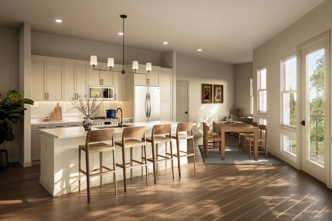 Expansive kitchen and dining area with a generous island, tailored finishes, and natural light supporting everyday meals and shared moments.