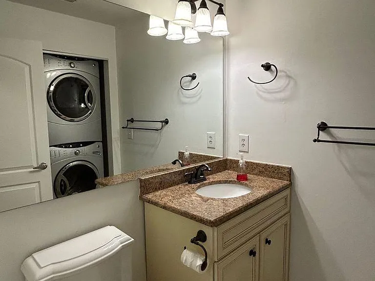 Convenient half bath located just off the main living area, featuring a large in-unit washer and dryer for easy everyday living.