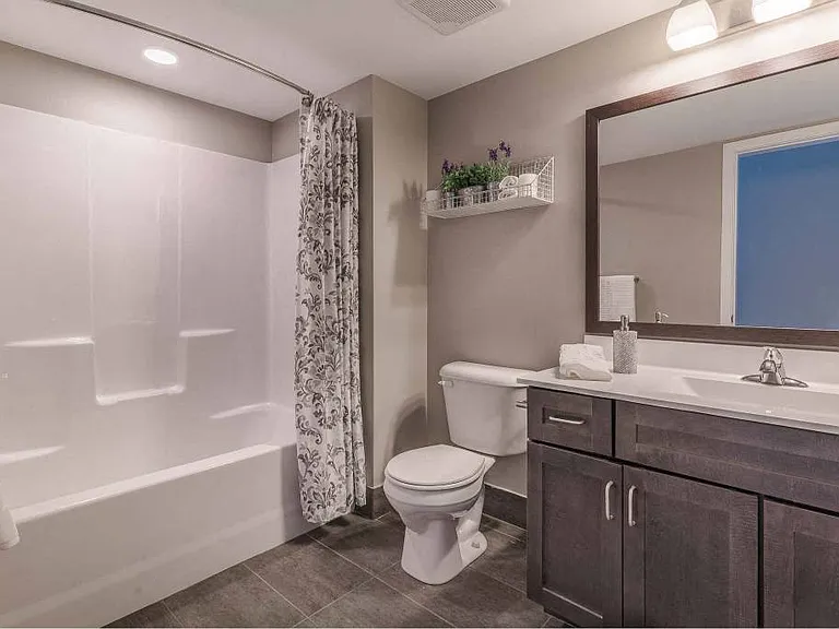 Second full bathroom with shower/tub combo, large vanity, and tile flooring