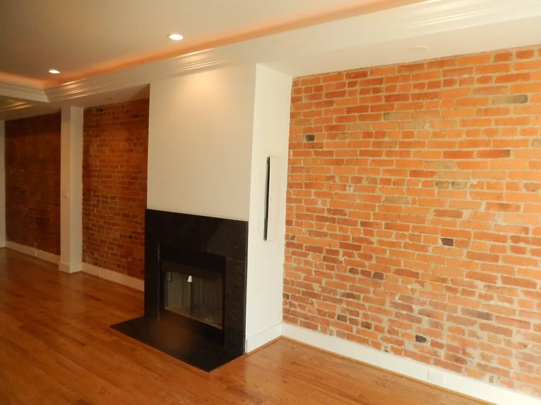 Beautiful exposed brick wall, LED lights built into the crown moldings, Gas fire place enclosed in ornate "black galaxy" marble.