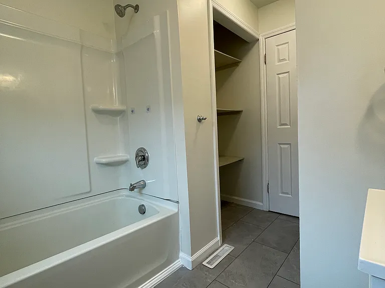 Main bathroom has large open storage shelves for linens and extras.