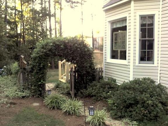 side view with walkway to fenced backyard