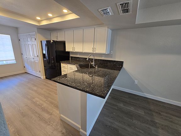 Beautifully remodeled kitchen featuring granite countertops, recessed LED lighting with dimmers, abundant cabinetry, and breakfast bar seating.