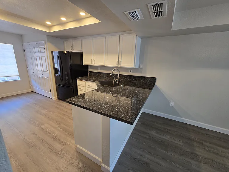 Beautifully remodeled kitchen featuring granite countertops, recessed LED lighting with dimmers, abundant cabinetry, and breakfast bar seating.