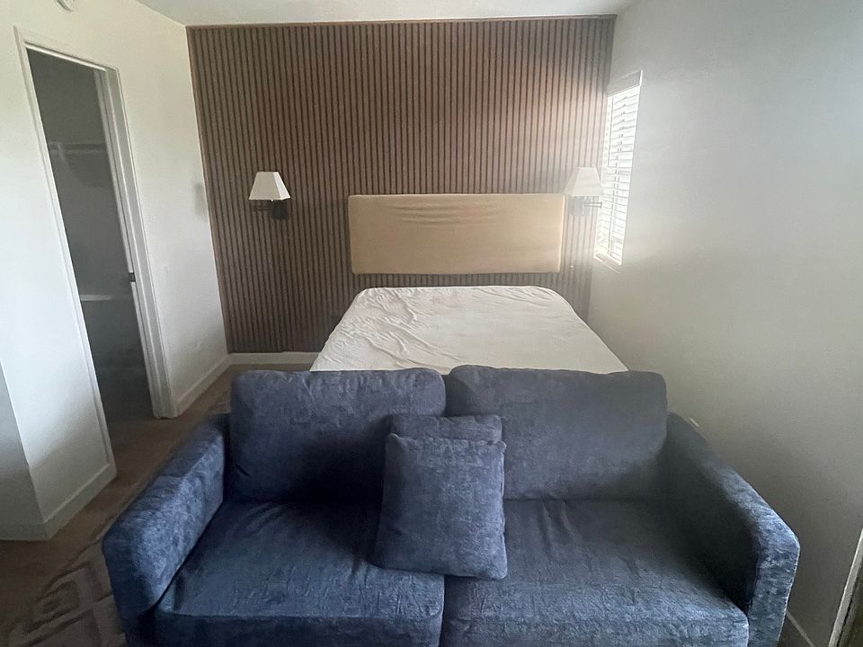 Studio living area is big enough for a queen bed, night stand, sofa, and entertainment center.