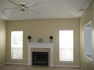 Living room has built-in TV cabinet and wood-buring fireplace.