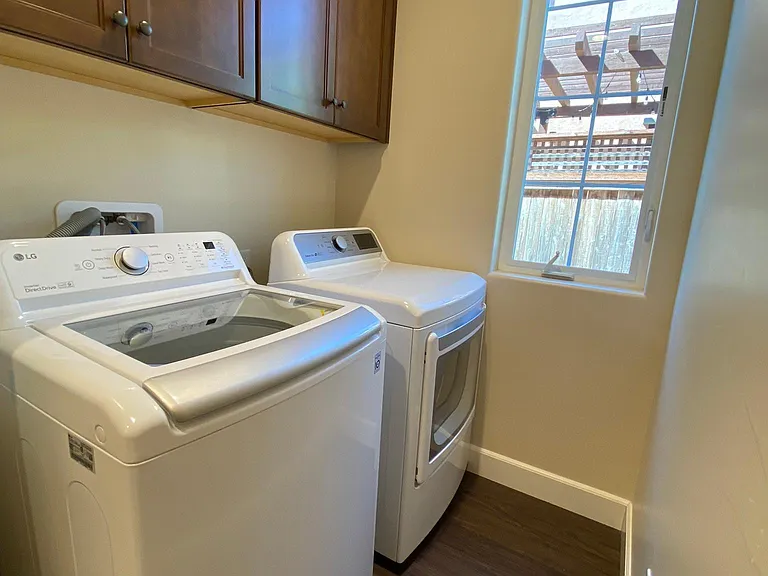 Dedicated laundry room with washer, dryer, and additional overhead storage cabinets.