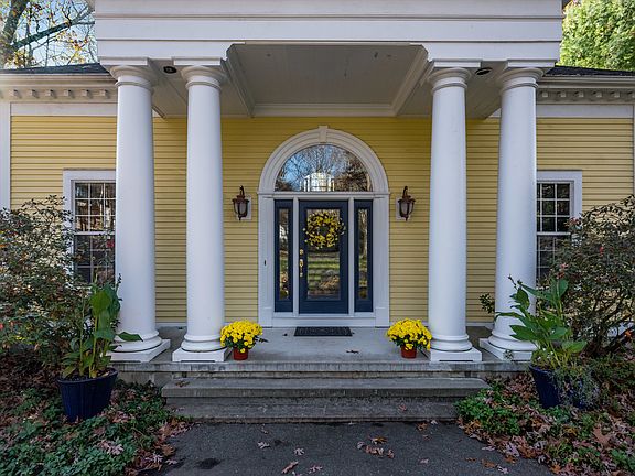 Stunning front entrance with stone porch and dramatic columns.