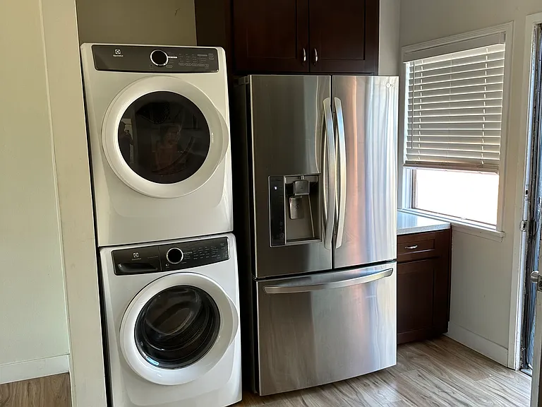 Washer, Dryer and Refrigerator at back door with small counter nook by window.