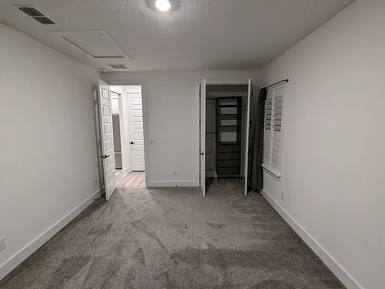 Bedroom Facing Entry with Open Closet Showing Built In