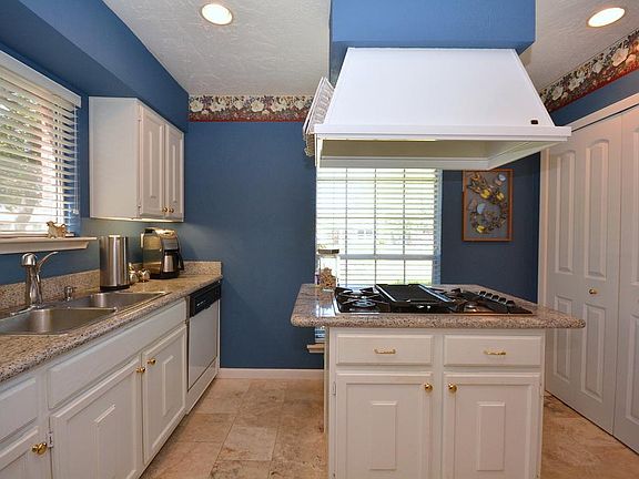 Kitchen with Granite Counter Tops and Six Burner Gas Stove.
