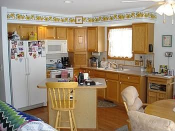 The open and beautiful kitchen with center island and plenty of solid wood cabinetry, all appliances