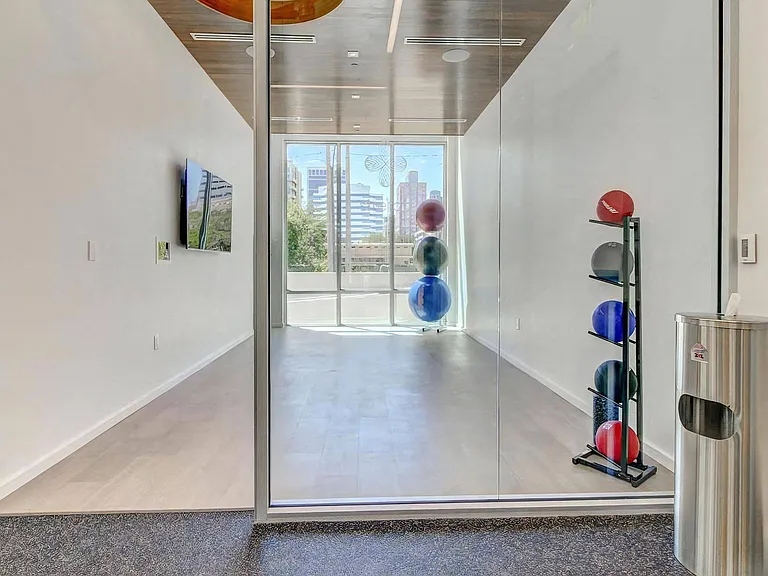 Yoga and Stretch Studio With Wood Ceiling, Wall-Mounted TV, and Floor-to-Ceiling Windows