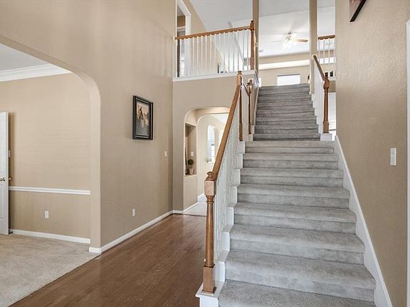 A traditional staircase leads you to the upstairs living spaces! This staircase also has "Hurricane Room" with flooring and electrical outlet.