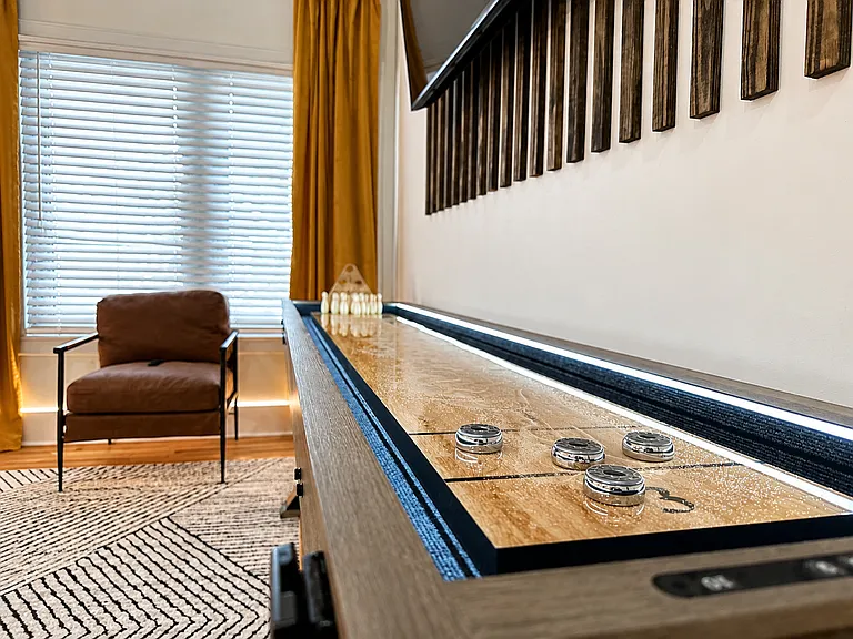 The Five Point Loft game room is ready for the challenge! This entertaining space boasts a large smart tv, plenty of games, shuffleboard, plush bean bags and seating, and playful lounge energy upstairs.