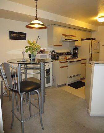 Older picture. New hardwood floors in living room and kitchen, New stove top in kitchen. Small breakfast area with a pantry shelf closet. Kitchen has electric stove-top, refrigerator, dishwasher, sink with garbage disposal.