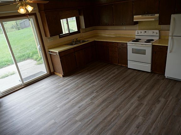 Large kitchen with a sliding glass door leading to a huge, fully-fenced back yard.