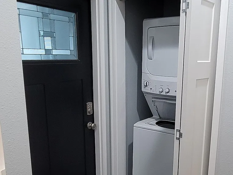 Washer and dryer located in shared private entryway for both units.