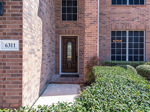 A lovely 2-story covered porch surrounded by a lush landscape welcomes you in!
