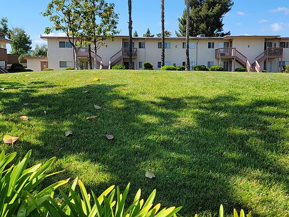 Large grassy areas with well cared for landscaping around buildings at Plaza Verde Apartments in Escondido, California.