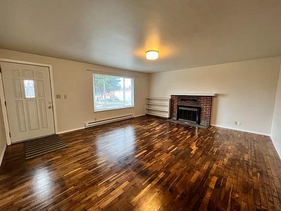 Newly refinished hardwood floors and large picture window in the living room. Brick fireplace with built in shelving. Kitchen and dining room is on the other side of the right wall.