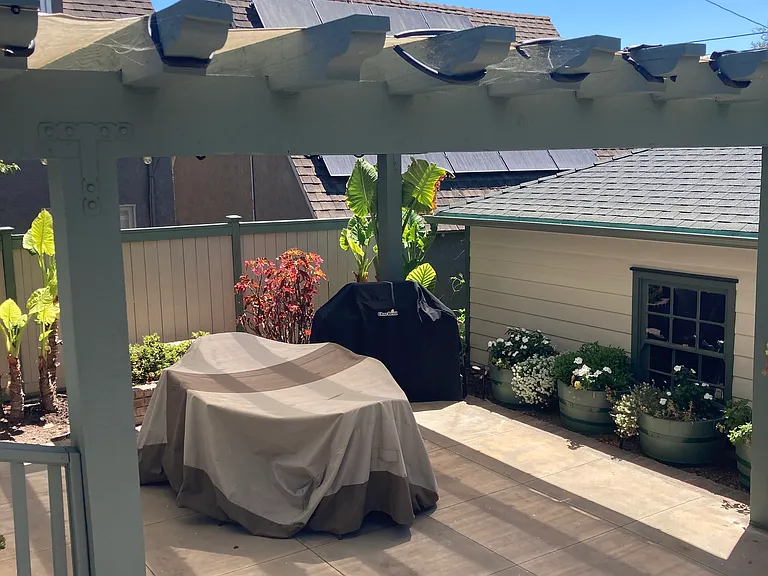 Shaded pergola with dining set and BBQ