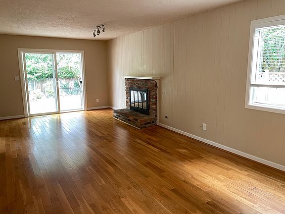 Family room formal dining area with gas fireplace. Slider to patio and outbuilding.