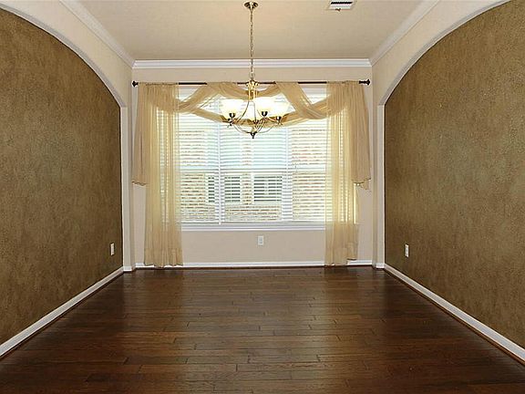 Dining room with crown molding, hardwoods, and faux finishes.