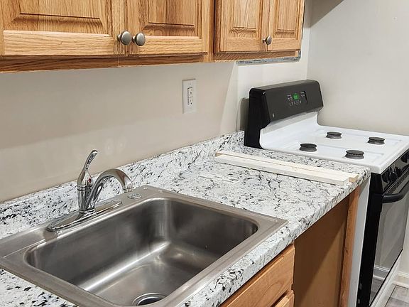Galley kitchen with new floors and countertops. Stove not finished.