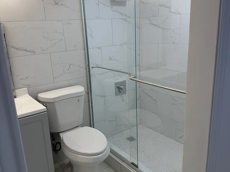 All tile shower with glass doors.