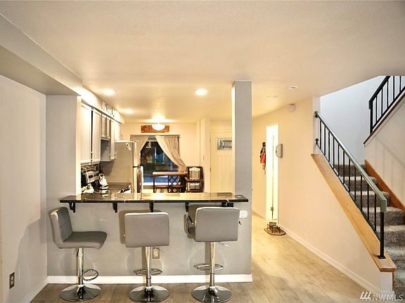 View of the front entrance/kitchen from the living room. Open concept between kitchen and living room, with breakfast bar!