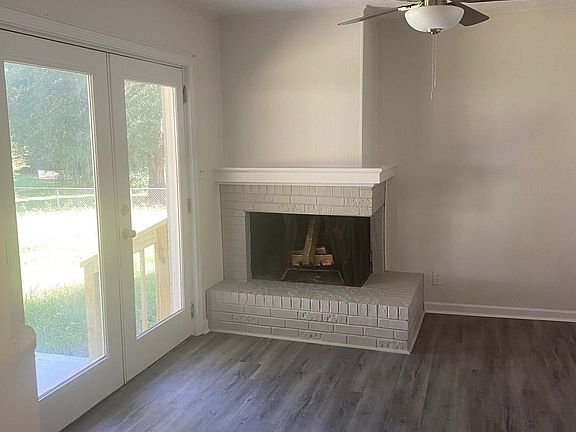Den with fireplace adjacent to kitchen.