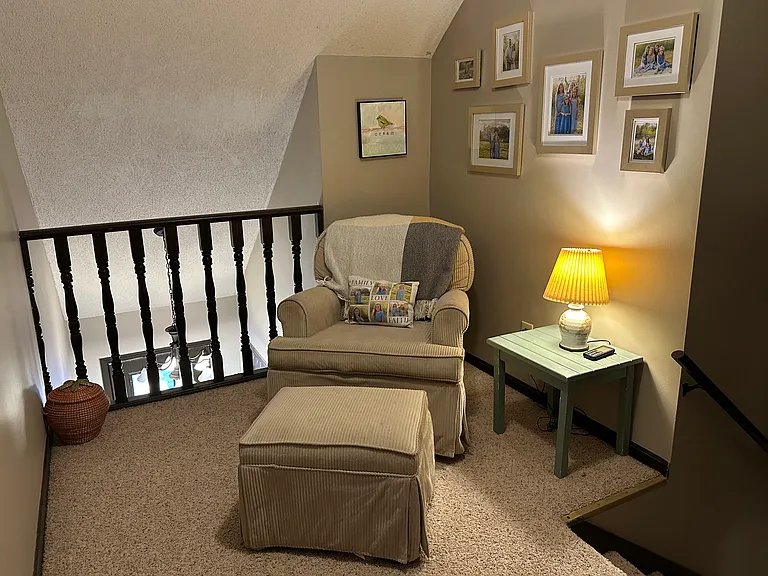This cozy reading nook offers the perfect place to relax and unwind. Just beyond the railing is the front entry, with the stairway to the fifth level conveniently located to the leftt.