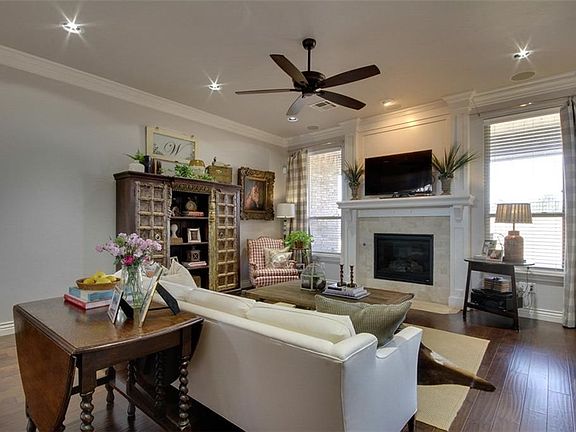 Open floor plan with more gorgeous white crown molding hand-scraped wood floors ad gas fireplace.
