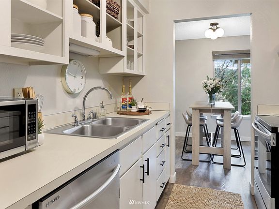 Walkthrough galley kitchen with open shelving allows for easy meal prep. 