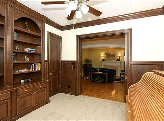 Pocket French doors open into the foyer and look onto the formal parlor area with fireplace across the hallway.