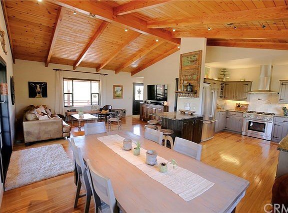 Great room has glass French doors out to the covered wrap-around porch, and many windows that fill the room with natural light.
