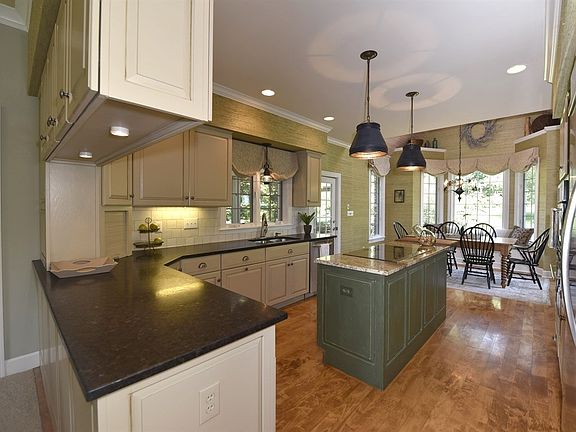 Warm, welcoming kitchen features honed granite counter, maple floor