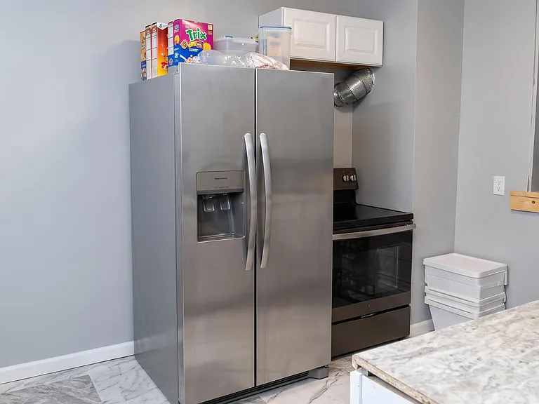 Eat-in kitchen featuring stainless steel refrigerator with water/ice dispenser and a full-size range for everyday cooking.